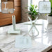 Disassembled white plastic hook components are displayed on a marble countertop, with insets showing the assembled hook.