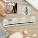 A white LED vanity light with four round bulbs is displayed on a wooden surface with bath accessories and product – view 3