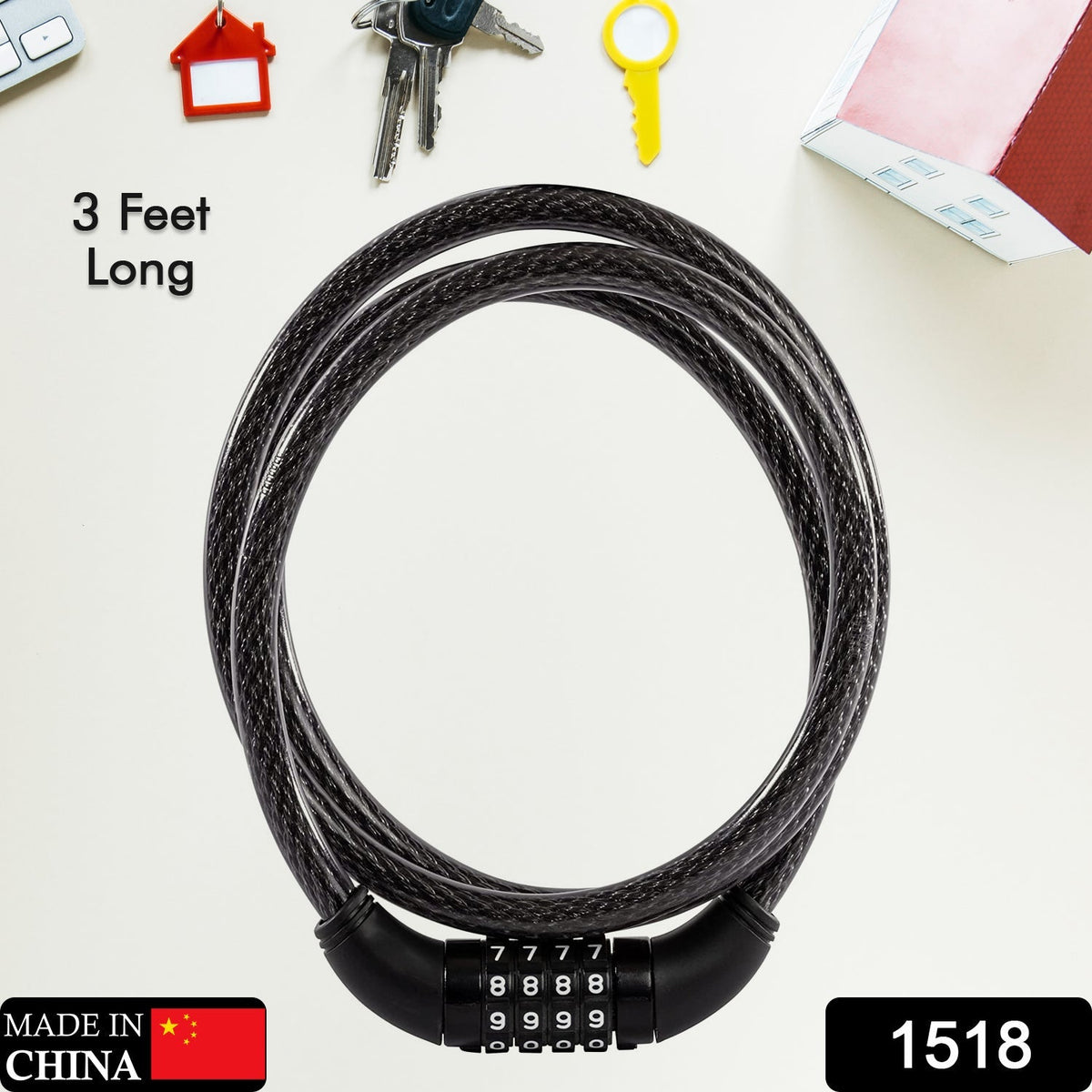 A coiled black cable lock with a four-dial combination lies flat on a light-colored surface with keys and a red house icon.