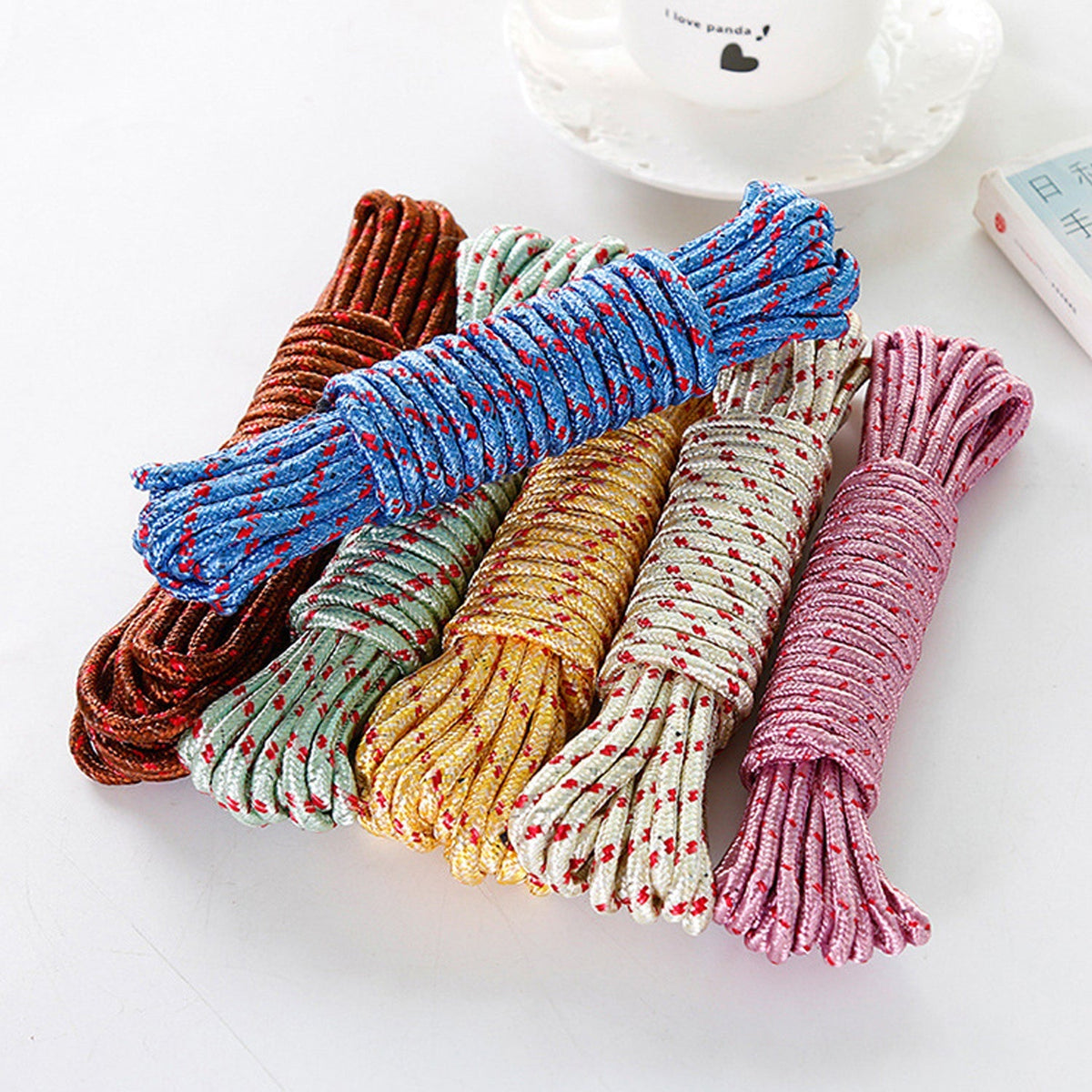 Six coiled ropes in various colors: brown, light green, cream, blue, yellow, and pink, on a white surface.