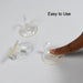 Transparent suction cup hooks holding kitchen utensils on a smooth surface.