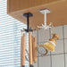 Two rotating hooks, one black and one white, hang from a wooden cabinet, holding various kitchen utensils.