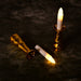 One gold-based LED candle stands upright while another lies on its side with the candle removed.