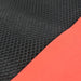 Close-up of the black mesh and red fabric textures of the laptop sleeve.
