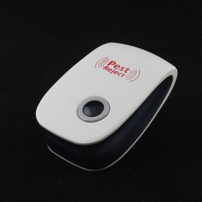 White and black pest repeller with a grey button on a dark background, viewed from an angle.