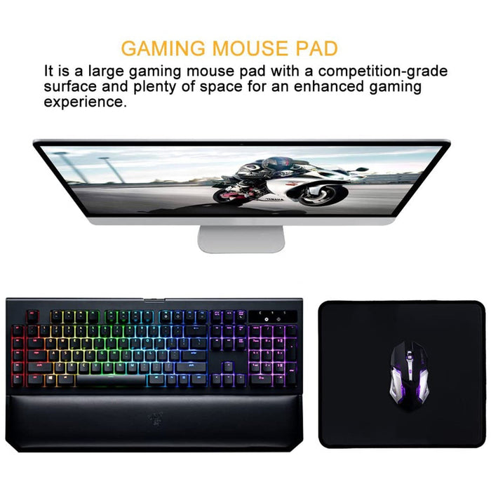 A black mouse pad with a gaming mouse next to a colorful gaming keyboard and a monitor displaying a motorcycle.