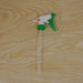A white and green trigger sprayer nozzle with a long, clear dip tube resting on a light wood surface.