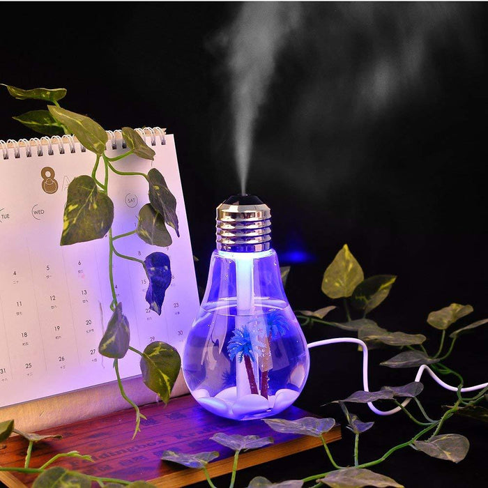 A blue bulb-shaped humidifier with palm trees inside emits mist next to a calendar and green vines.