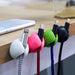 Transparent wire clips for desk organization, blending seamlessly with furniture.