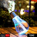 A single blue bulb-shaped humidifier with palm trees inside emits mist on a wooden surface.