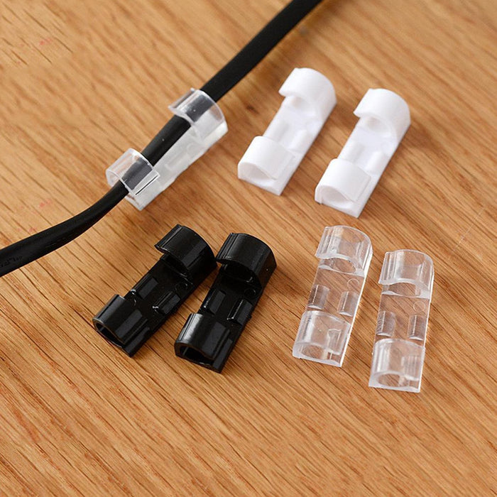 A black cable is secured by a clear clip, with two white, two black, and two clear loose clips on a wooden surface.
