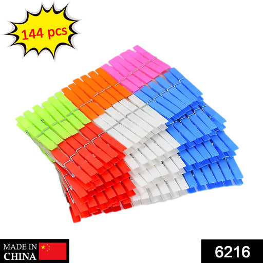 A large stack of colorful plastic clothes clips with a "144 pcs" label and "MADE IN CHINA" and "6216" at the bottom.