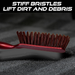 A close-up of the red and white handled brush with brown bristles on a dark textured surface, with text about stiff bristles.