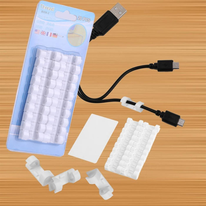 A blue package of white cable clips, a white adhesive strip, and loose clips with two cables.