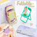 A stack of folded pastel chairs next to a teal chair holding a cat figurine, with a phone and text overlay.