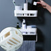 Multipurpose wall shelf installed in a modern kitchen, holding spices.