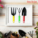 A yellow fork, green cultivator, and red trowel are neatly framed in white, with gardening items scattered around.