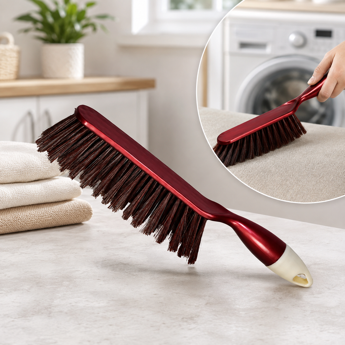 A red and white handled brush with brown bristles rests on a light counter next to folded towels, with an inset showing it