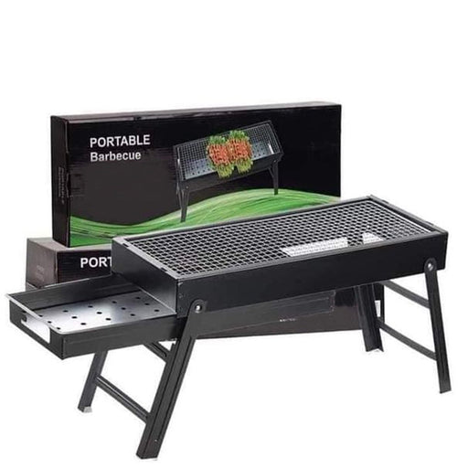 Black portable barbecue grill with an open ash tray and its product box in the background.