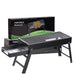 Black portable barbecue grill with an open ash tray and its product box in the background.