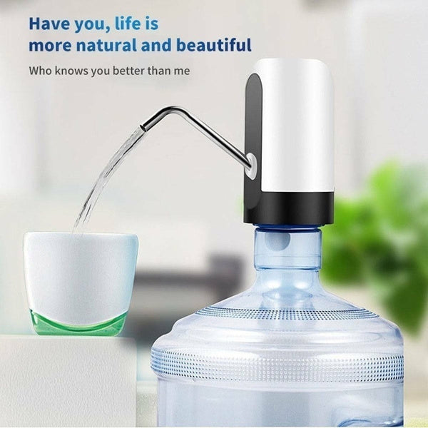 White and black automatic water pump dispensing water into a small white and green cup from a large water bottle.