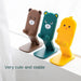 Three cartoon phone stands, brown bear, green bear, and yellow duck, are lined up on a windowsill.