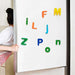 Brightly coloured magnetic letters displayed on a whiteboard, ready for learning.