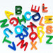 Kids using magnetic letters to form words and learn spelling skills.