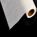 A close-up of a roll of white baking paper with a serrated edge on a black background.