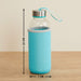 A clear glass bottle with a turquoise sleeve and lid, with dimensions of 22cm high and 7cm wide.
