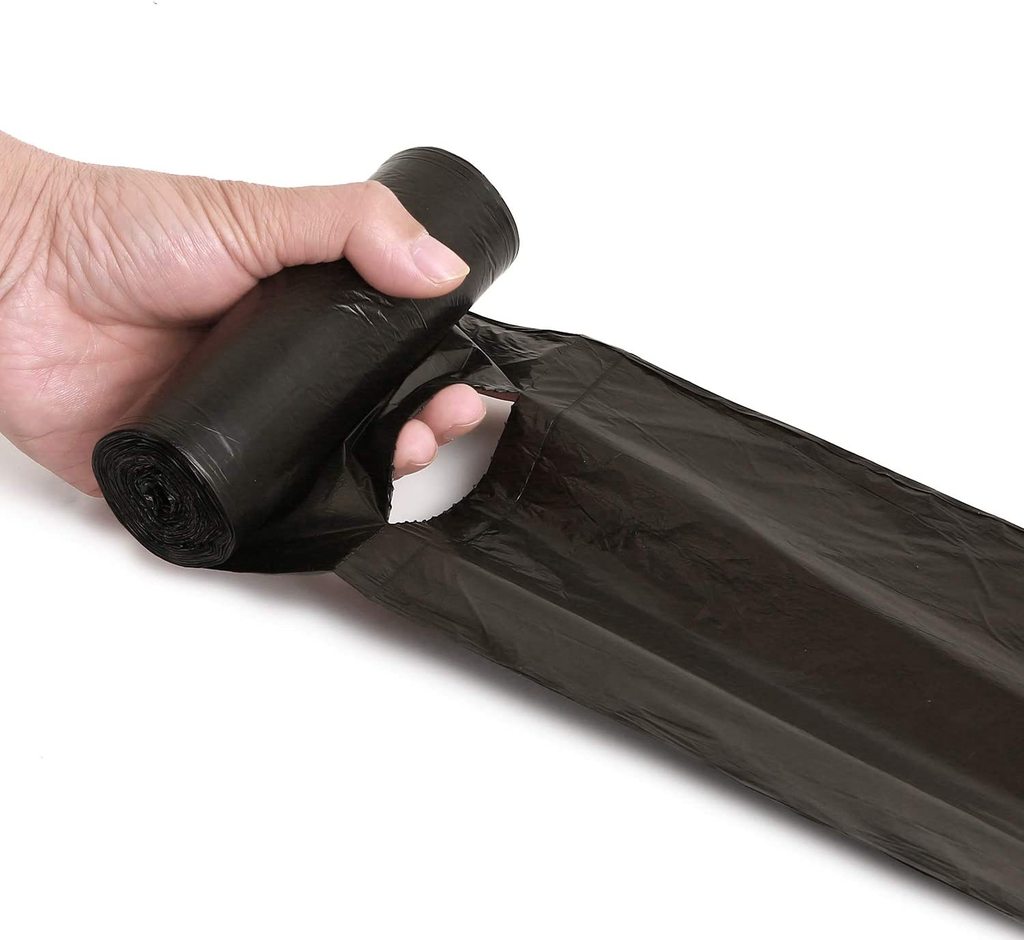 A hand holds a roll of black garbage bags while another hand pulls a bag from the roll.