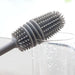 Hand holding a bottle cleaning brush, demonstrating its comfortable grip.