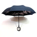 An open black reverse umbrella features a delicate pink cherry blossom pattern on its underside.