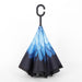 A closed reverse umbrella displays a gradient blue feather pattern, transitioning to black at the bottom.