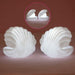 A child's hand reaching for the gentle glow of the Pearl Shell Night Lamp.