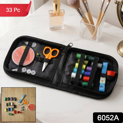 An open black sewing kit with colorful threads, orange scissors, and other accessories is shown on a white vanity with a '33
