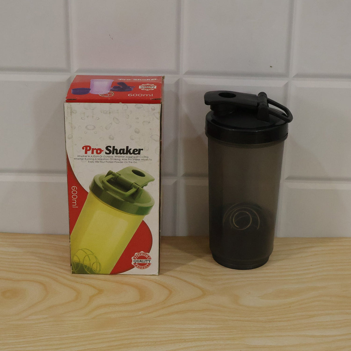 A grey and black shaker bottle sits next to its