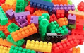 Hand holding a few small building blocks, demonstrating the compatible design.