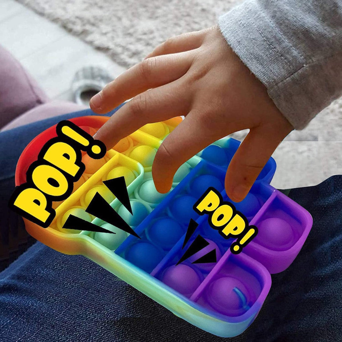 A child's hand presses a rainbow Among Us pop-it fidget toy, with