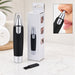 A black and silver nose hair trimmer stands next to its white box, with a small cleaning brush.