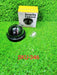 Black dome dummy security camera next to its yellow and white packaging box and small white screws, all on artificial green