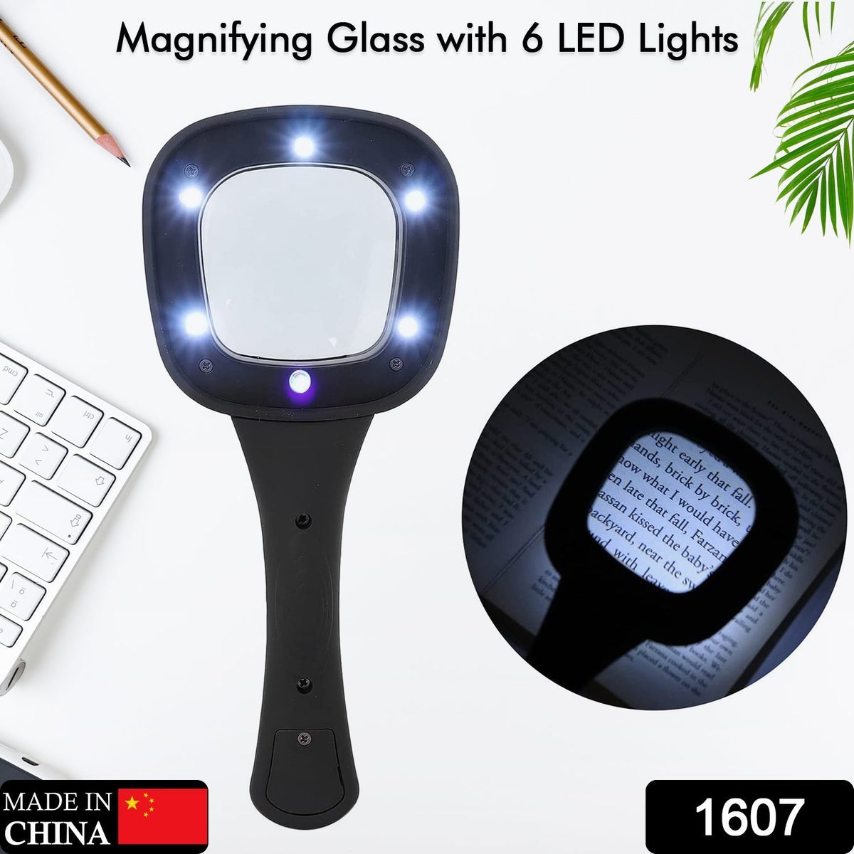 Black handheld magnifying glass with six bright LED lights on a white desk with a keyboard and plant. Inset shows magnified