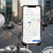 Smartphone securely held in the metal bike phone holder, attached to a rear view mirror on a bike.